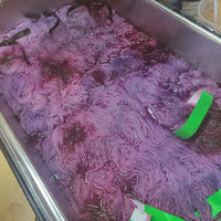 Wolle die in Pink und lila tönen gefärbt wird.